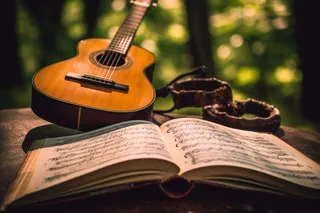 公园里长椅放着打开的书籍和吉他摄影图