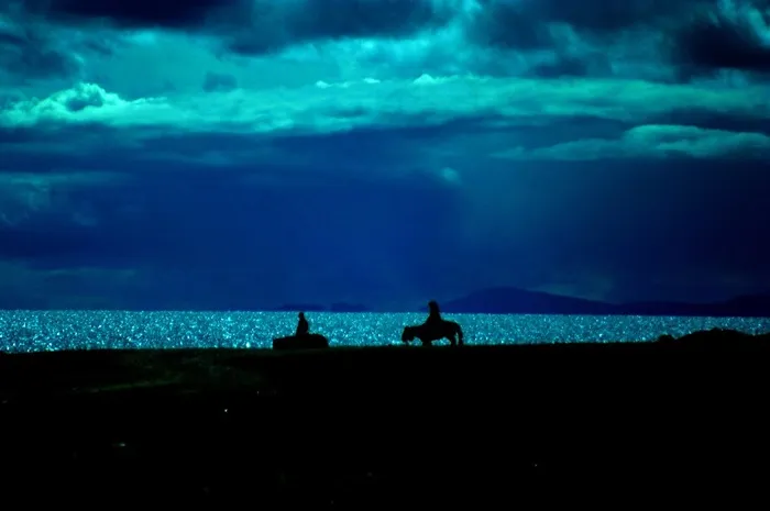 暮霭时分西藏纳木错湖畔的骑马牧民