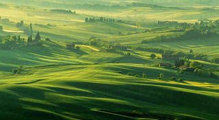 春日阳光下绿色连绵山脉草坪