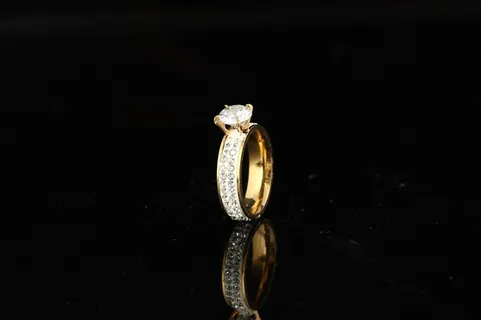 一只立在黑色桌面上的戒指珠宝图片