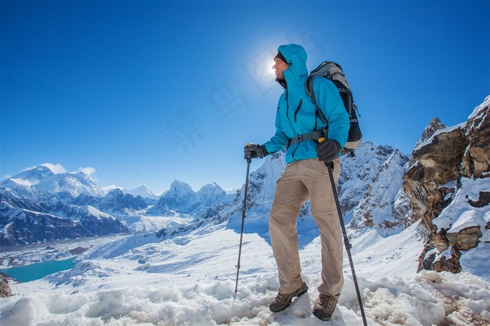 爬上雪山山顶的男子高清摄影图片