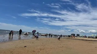 夏日炎炎下的海边，彩云飘飘人头攒动