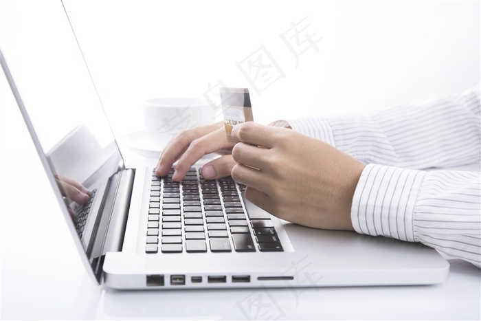 手拿银行卡操作电脑键盘