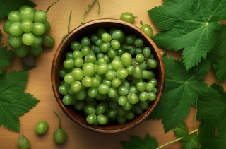 一个装有绿葡萄的碗放在桌子上的摄影图