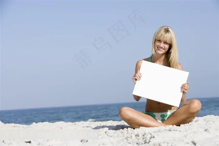抱白纸板微笑的泳装美女