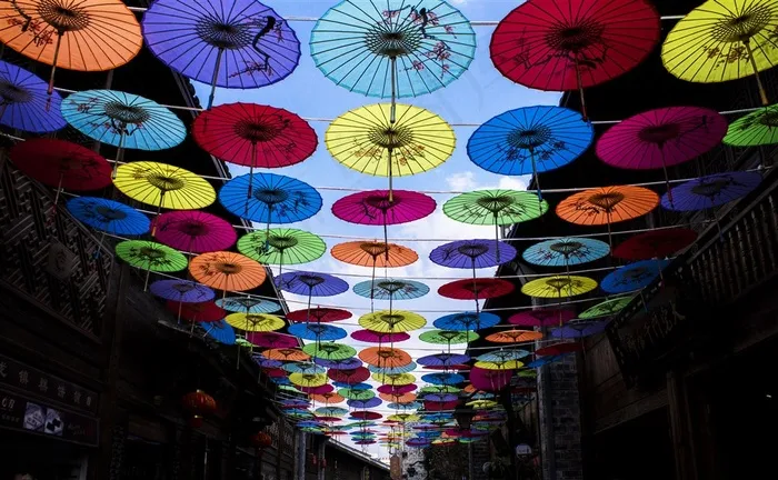 仰望漂浮在晴朗天空中五颜六色的伞