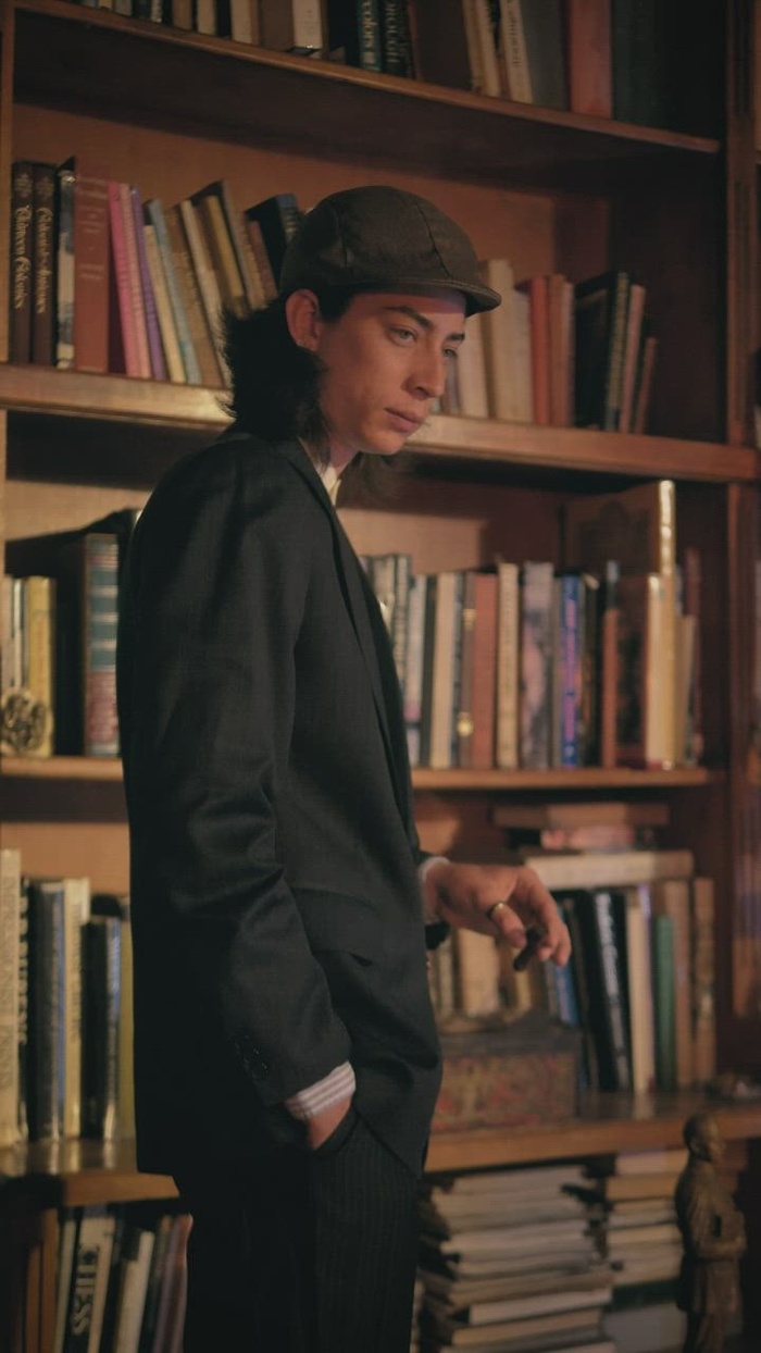 友好的老时尚男人在书店抽雪茄