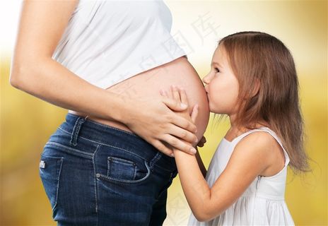 小女孩亲吻孕妇肚子摄影素材