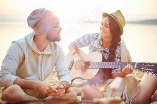 正在水边弹吉他的美女高清摄影图