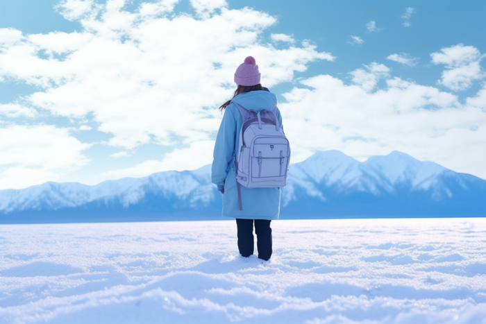 冬天一个女生背包走在山林里雪景摄影图