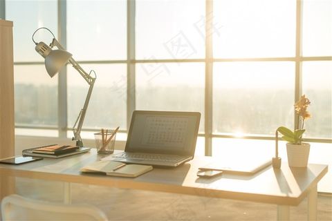 木桌子上的笔记本和台灯