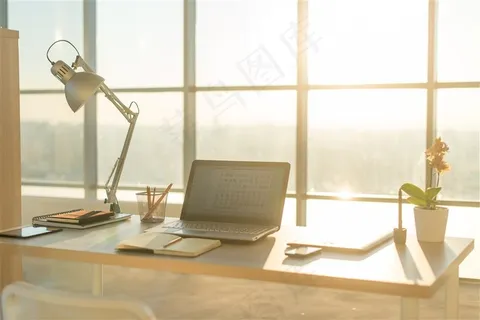 木桌子上的笔记本和台灯