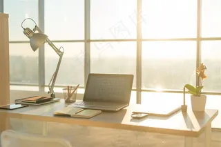 木桌子上的笔记本和台灯