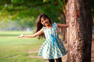 大树旁的小女孩儿童图片