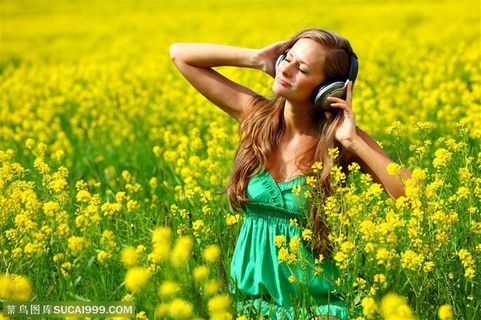花丛中戴耳机听音乐的美女图片