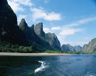 天空下石峰边的江水