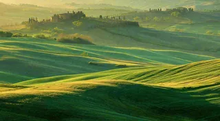 春日阳光下绿色连绵山脉草坪