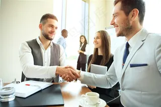 办公室里的工作人员和握手的商务人士高清图片