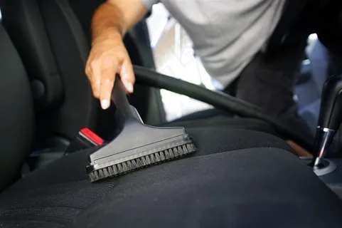 洗车工人在吸坐垫上的灰尘