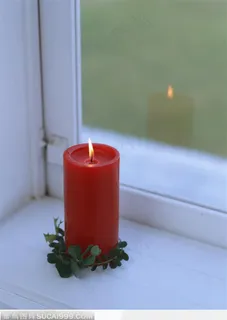 窗台上点燃的一支红色蜡烛