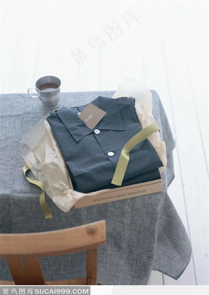桌子上的一杯茶和一件新拆开的黑色衬衫