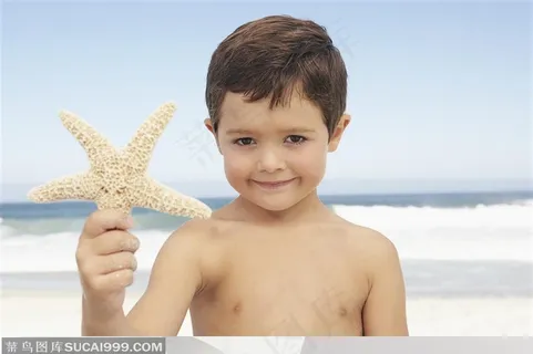 海边手拿海星的外国小男孩