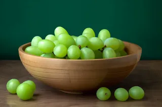 一个装有绿葡萄的碗放在桌子上的摄影图