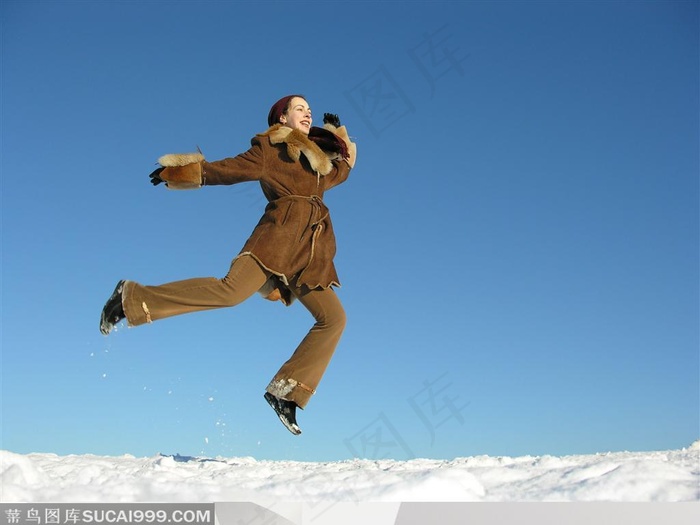 穿皮革大衣的国外美女在雪地上跳跃