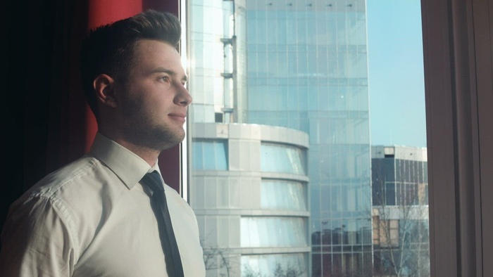 在窗口附近的年轻商人画象