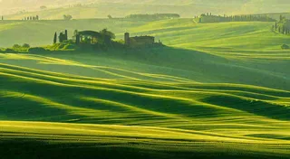 春日阳光下绿色连绵山脉草坪