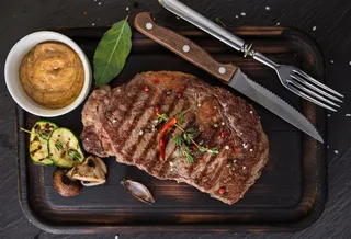 木制餐桌上的牛排高清图片