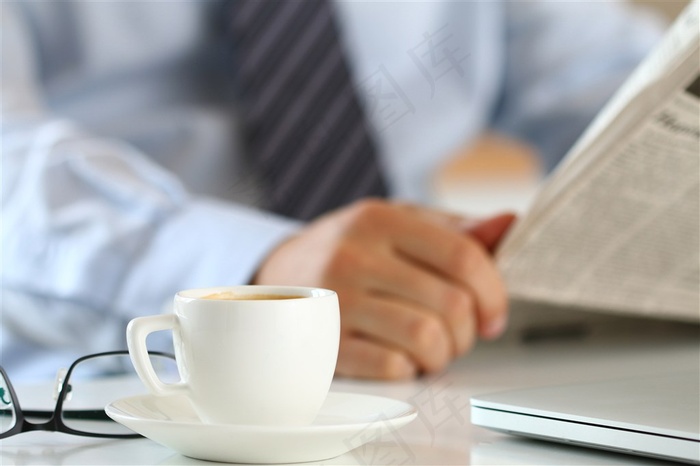 在电脑前看报的男子高清摄影图