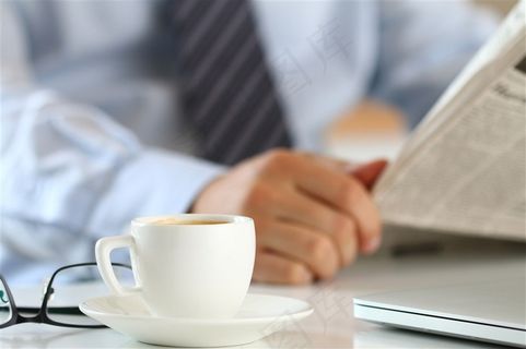 在电脑前看报的男子高清摄影图