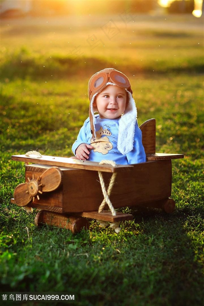 橙光下坐在木飞机里的飞行员小孩宝宝图片