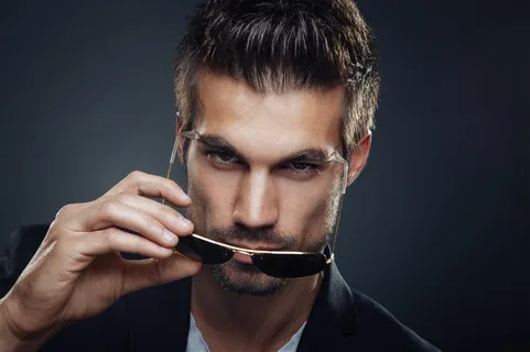 手中拿着太阳眼镜的帅哥高清图片