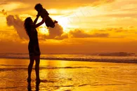 夕阳下抱着宝宝的妈妈