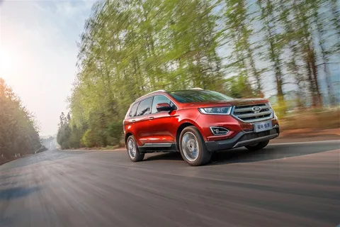 行驶在乡间树林里的道路上的美国福特锐界城市型越野车