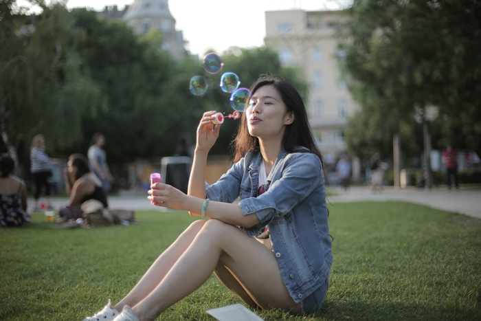 草坪上吹泡泡女生图片