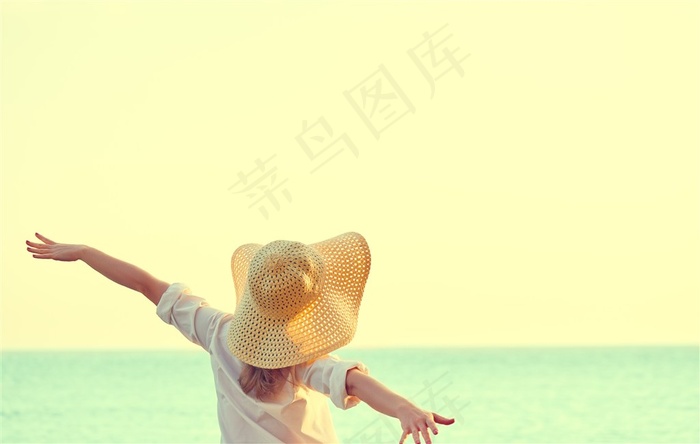 带着太阳帽在海边玩耍的女子