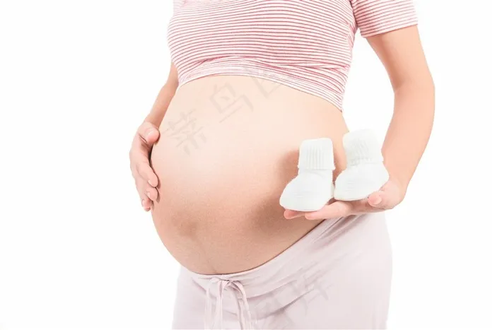 大着肚子拿着婴儿鞋的孕妇高清图片