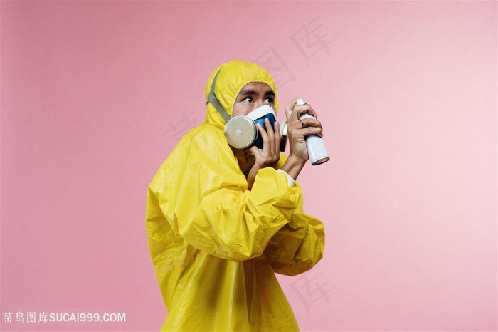 穿着黄色防护服戴防毒面具和喷酒精害怕病毒的样子