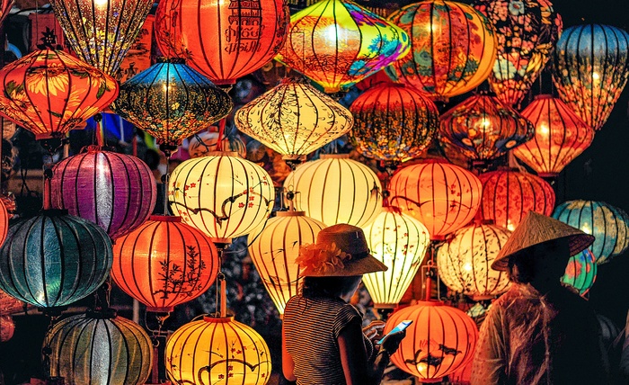 两人站在彩色纸灯笼附近
