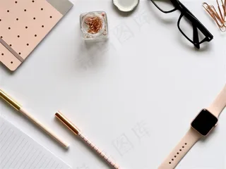 散落在白色桌面上眼镜框笔记本笔apple-watch