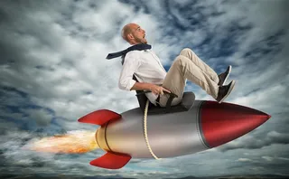 坐在火箭上飞翔在天空中的商务图片