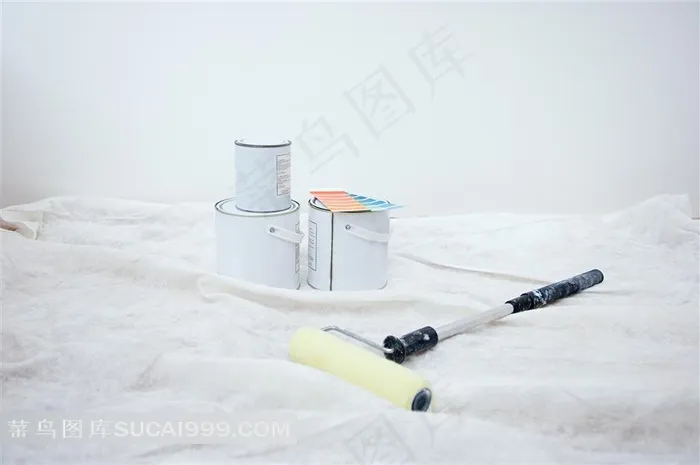 白色布上放的油漆桶和油漆刷