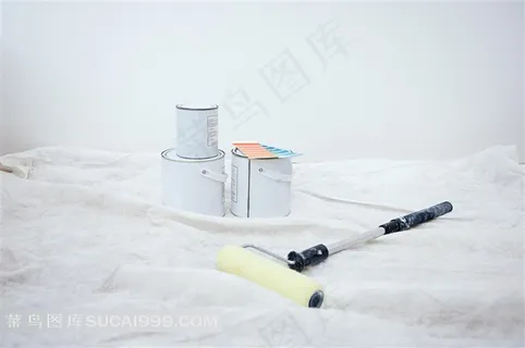 白色布上放的油漆桶和油漆刷