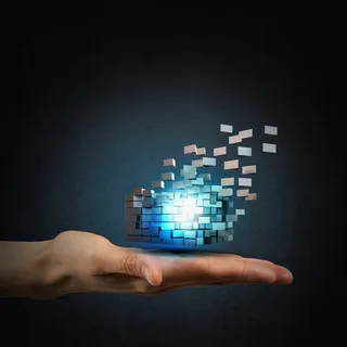 灰色背景中单手手掌上的蓝色小球高清摄影图片