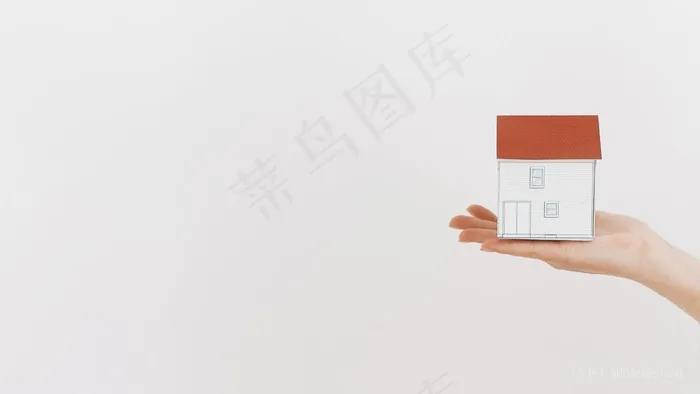 特写手拿着迷你房子模型白色背景