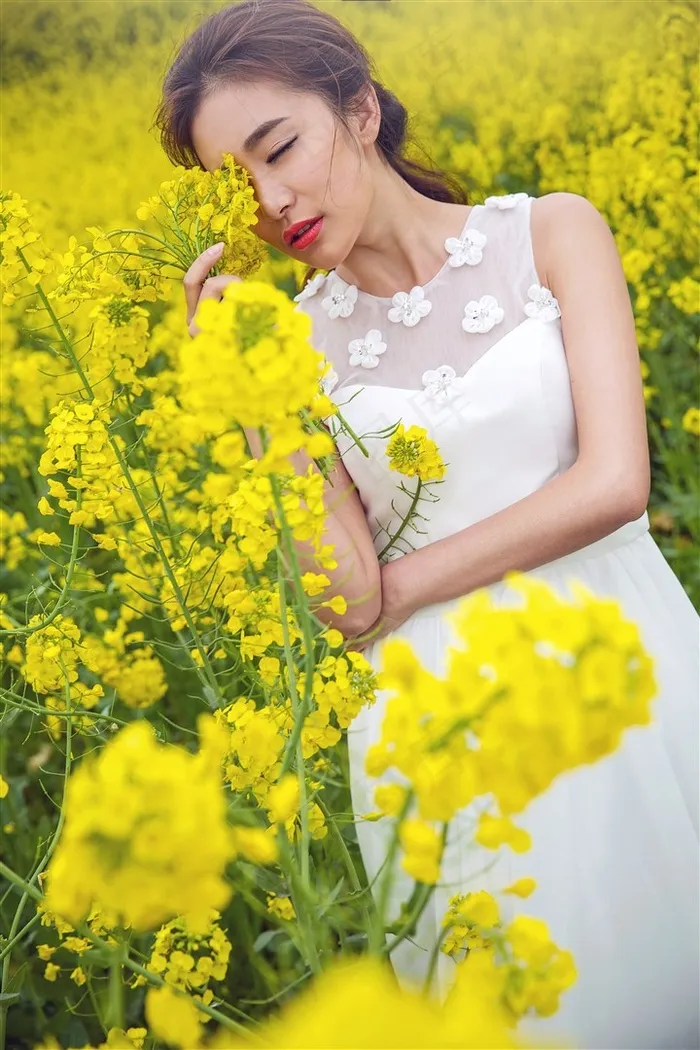 油菜花地中的白裙美女