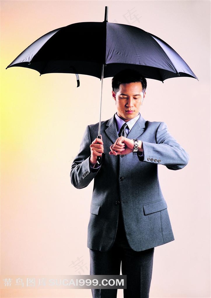 打伞看手表的商务男人
